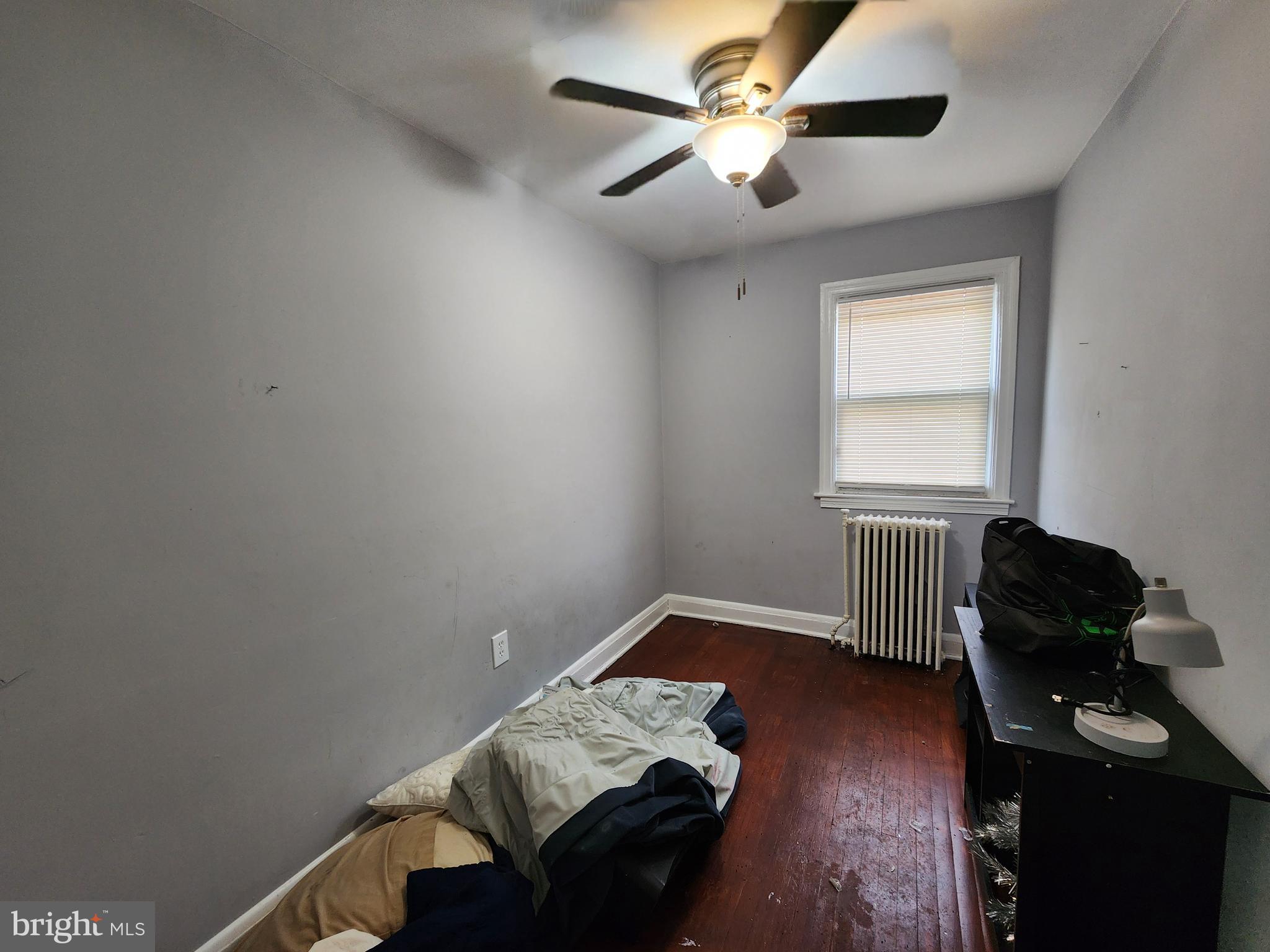 1310 Edison Highway Baltimore, MD 21213 - Photo 21 of 31 a bedroom with a bed and wooden floor