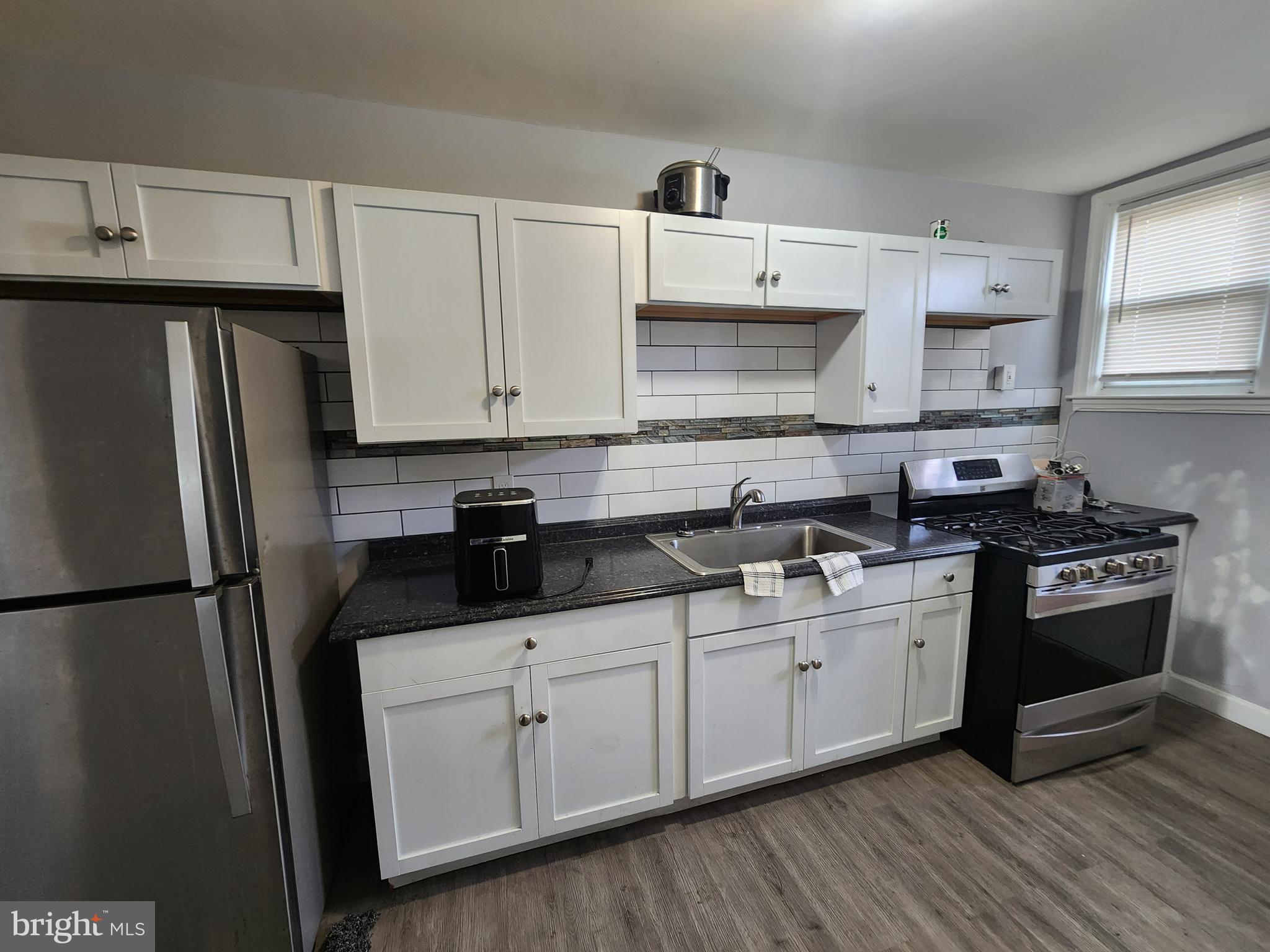 1310 Edison Highway Baltimore, MD 21213 - Photo 6 of 31 a kitchen with stainless steel appliances a sink stove refrigerator and cabinets