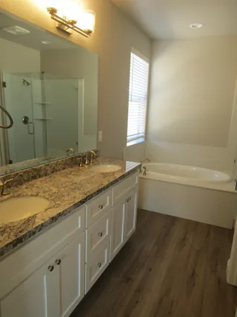 a bathroom with a granite countertop sink a toilet and bathtub