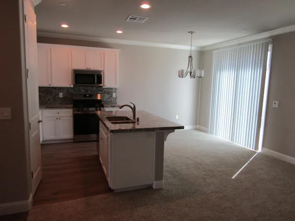 a kitchen with kitchen island stainless steel appliances a sink stove and refrigerator