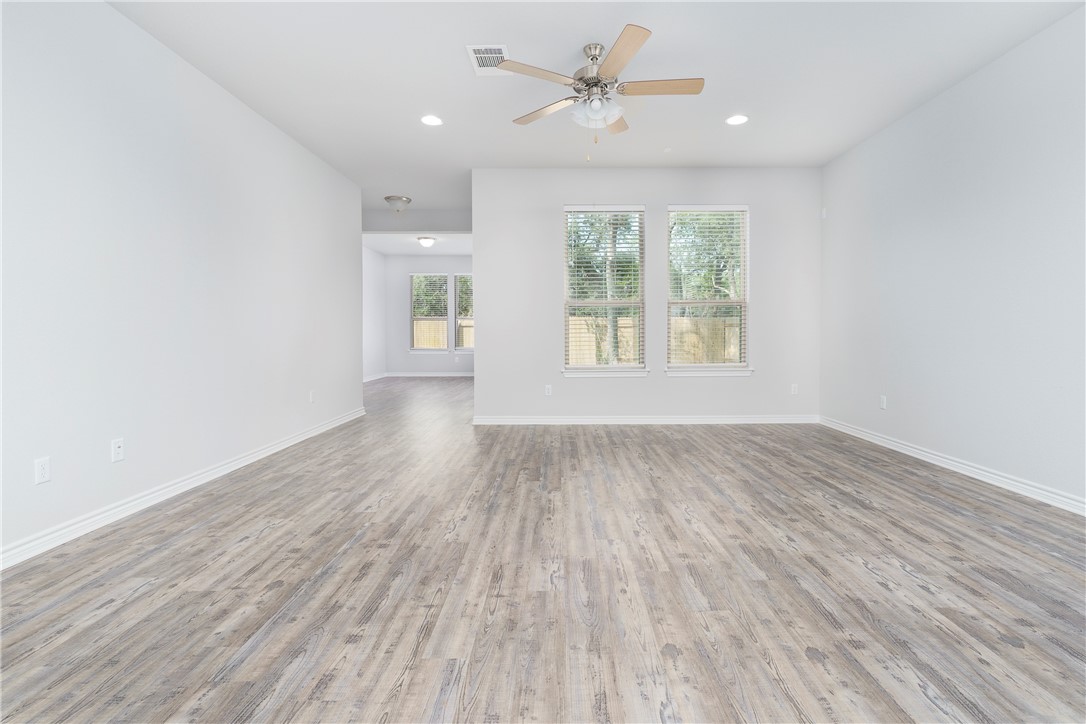 1613 Winding Stream Trail, Unit 75 Leander, TX 78641 - Photo 11 of 23 wooden floor in an empty room with a window