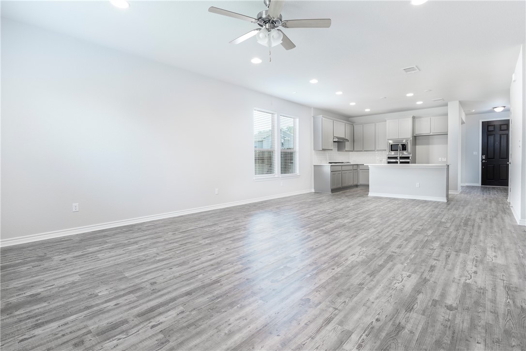 1613 Winding Stream Trail, Unit 75 Leander, TX 78641 - Photo 12 of 23 a view of large kitchen with wooden floor and window