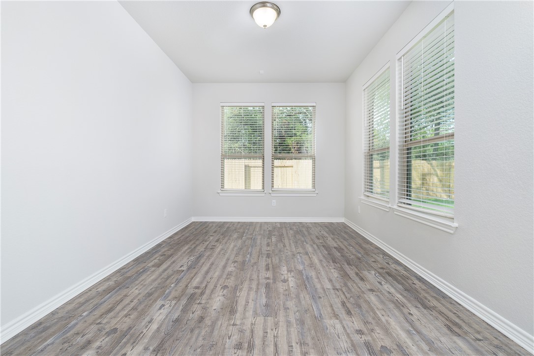 1613 Winding Stream Trail, Unit 75 Leander, TX 78641 - Photo 14 of 23 an empty room with wooden floor and windows