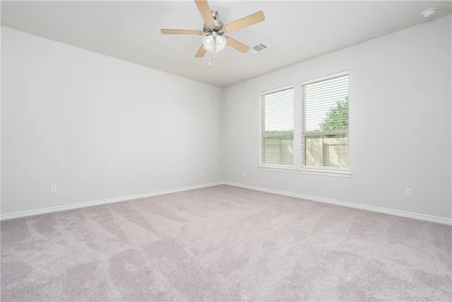 an empty room with a window and a ceiling fan
