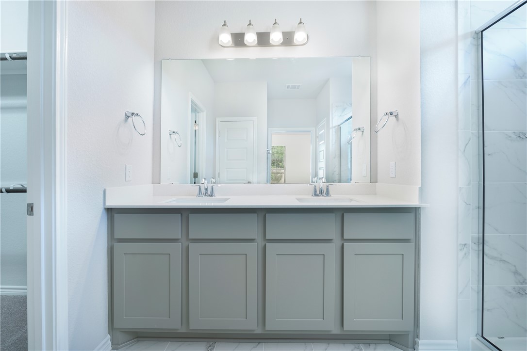 1613 Winding Stream Trail, Unit 75 Leander, TX 78641 - Photo 16 of 23 a bathroom with a sink vanity and a mirror