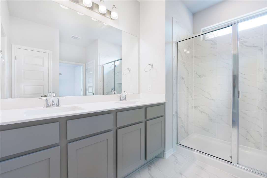 1613 Winding Stream Trail, Unit 75 Leander, TX 78641 - Photo 17 of 23 a bathroom with a shower sink and mirror