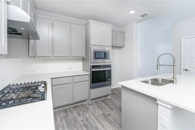 a kitchen with kitchen island a sink stainless steel appliances and cabinets