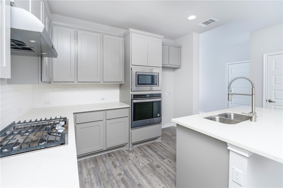 1613 Winding Stream Trail, Unit 75 Leander, TX 78641 - Photo 3 of 23 a kitchen with kitchen island a sink stainless steel appliances and cabinets