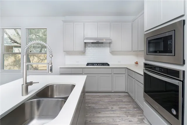a kitchen with granite countertop a sink and stove top oven