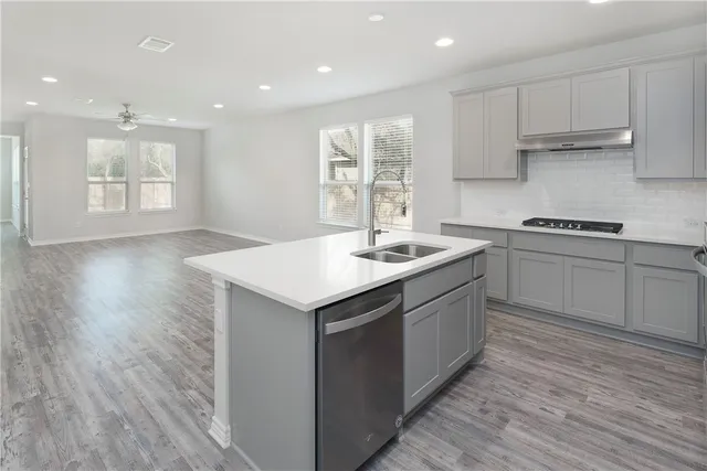 a kitchen with a sink cabinets and wooden floor