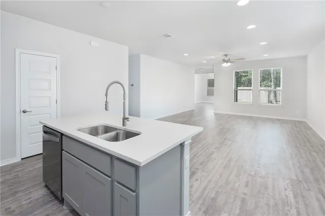 a kitchen with a sink cabinets and wooden floor