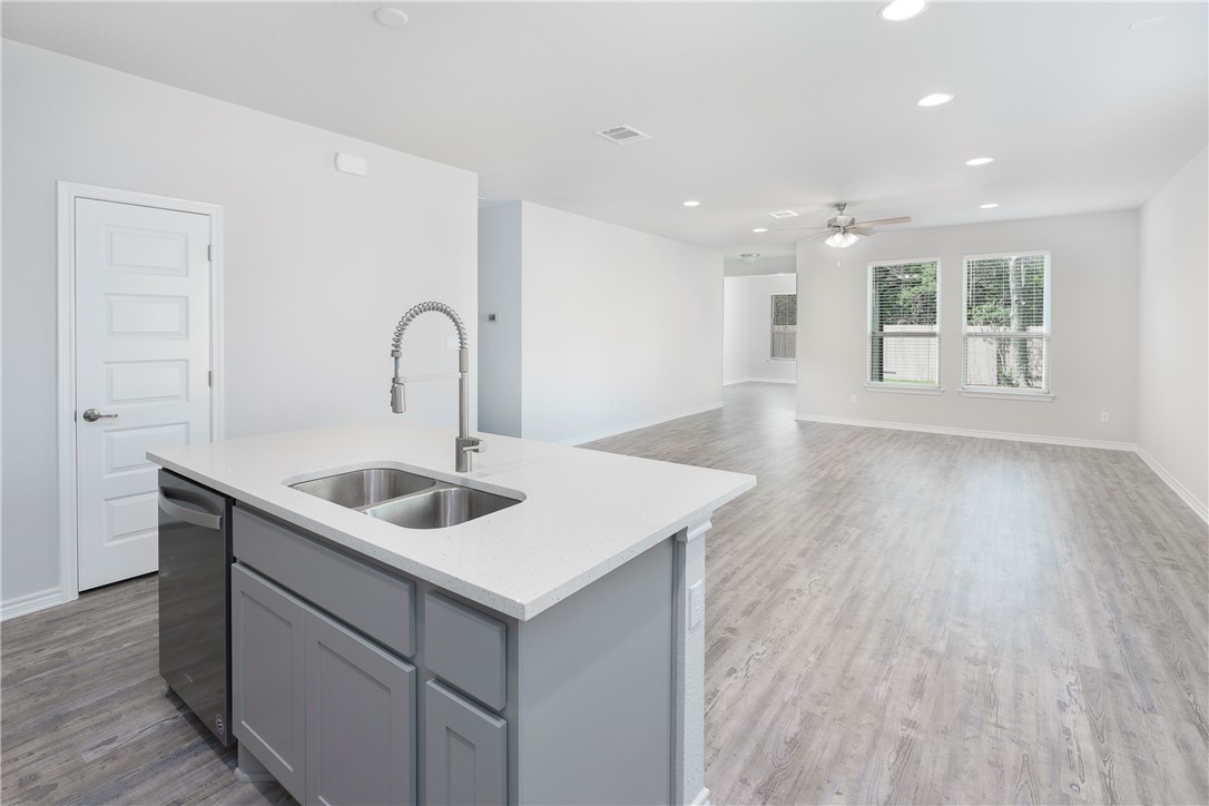 1613 Winding Stream Trail, Unit 75 Leander, TX 78641 - Photo 7 of 23 a kitchen with a sink cabinets and wooden floor