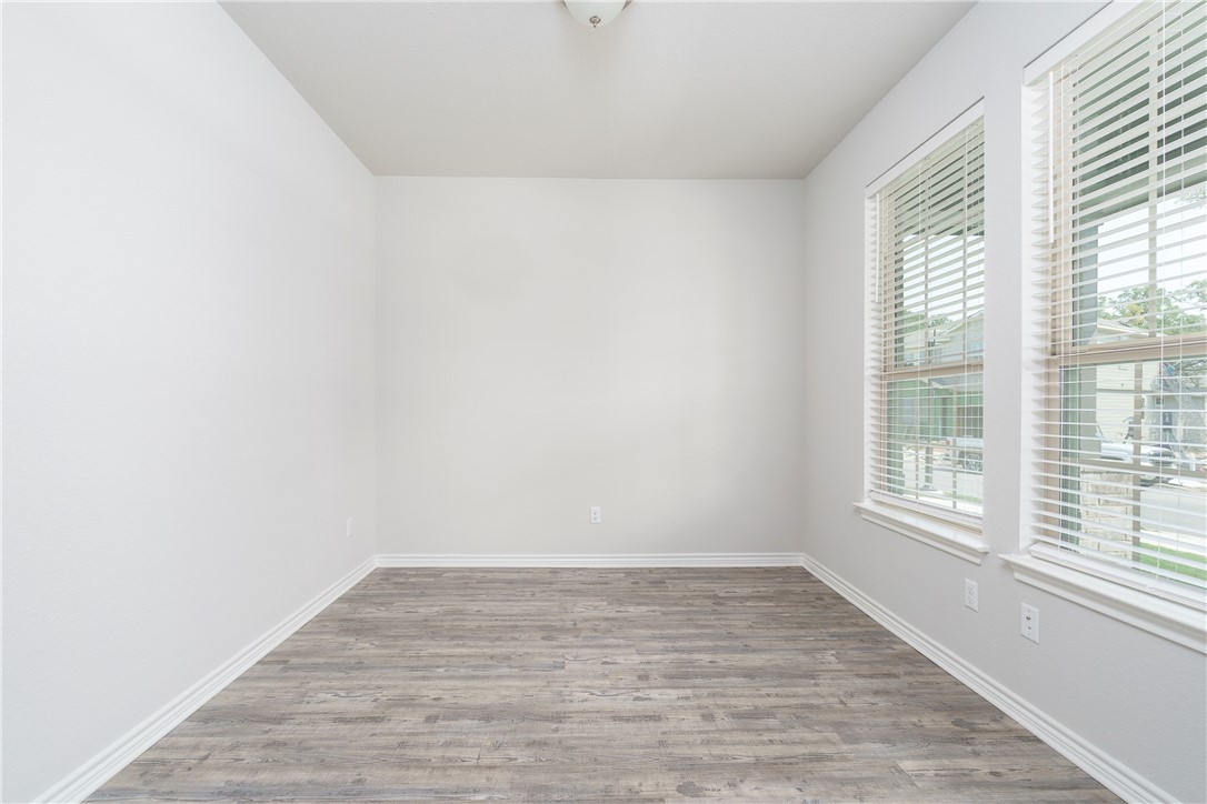 1613 Winding Stream Trail, Unit 75 Leander, TX 78641 - Photo 8 of 23 a view of an empty room with wooden floor and a window