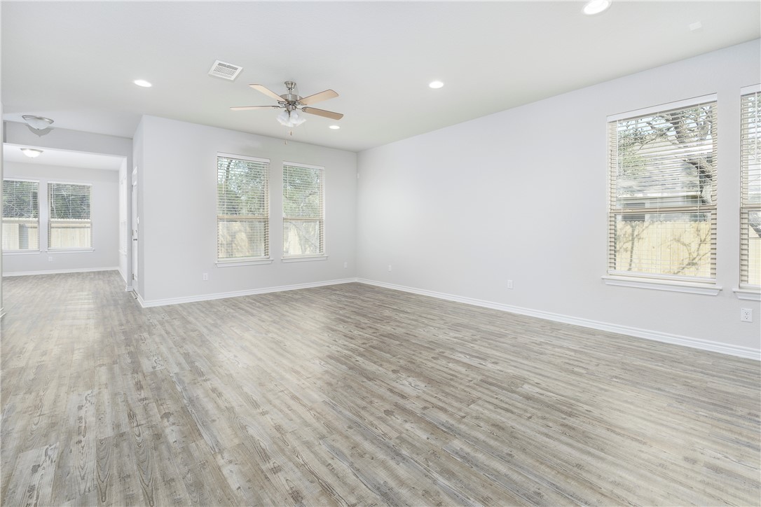 1613 Winding Stream Trail, Unit 75 Leander, TX 78641 - Photo 10 of 23 an empty room with wooden floor and windows