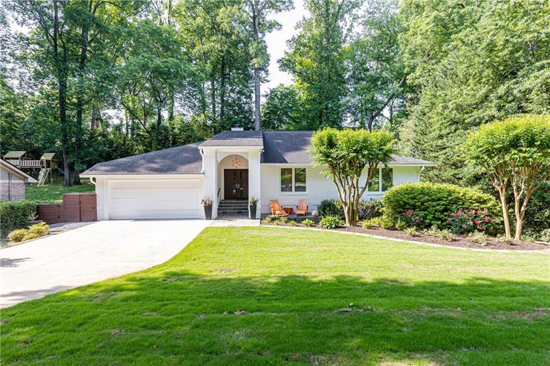 a front view of a house with yard and green space