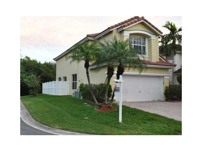 a front view of a house with a yard and trees