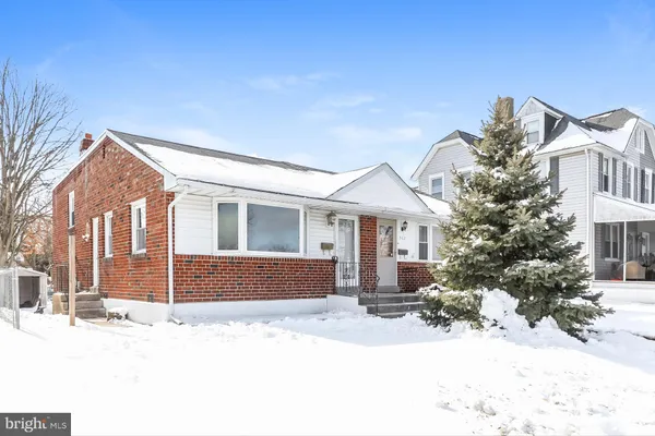 a front view of a house with a yard covered in snow