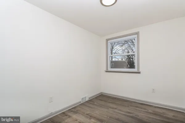 a view of a small space with wooden floor and a window