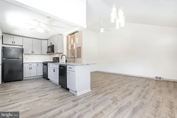 a kitchen with a sink cabinets stainless steel appliances and a chandelier