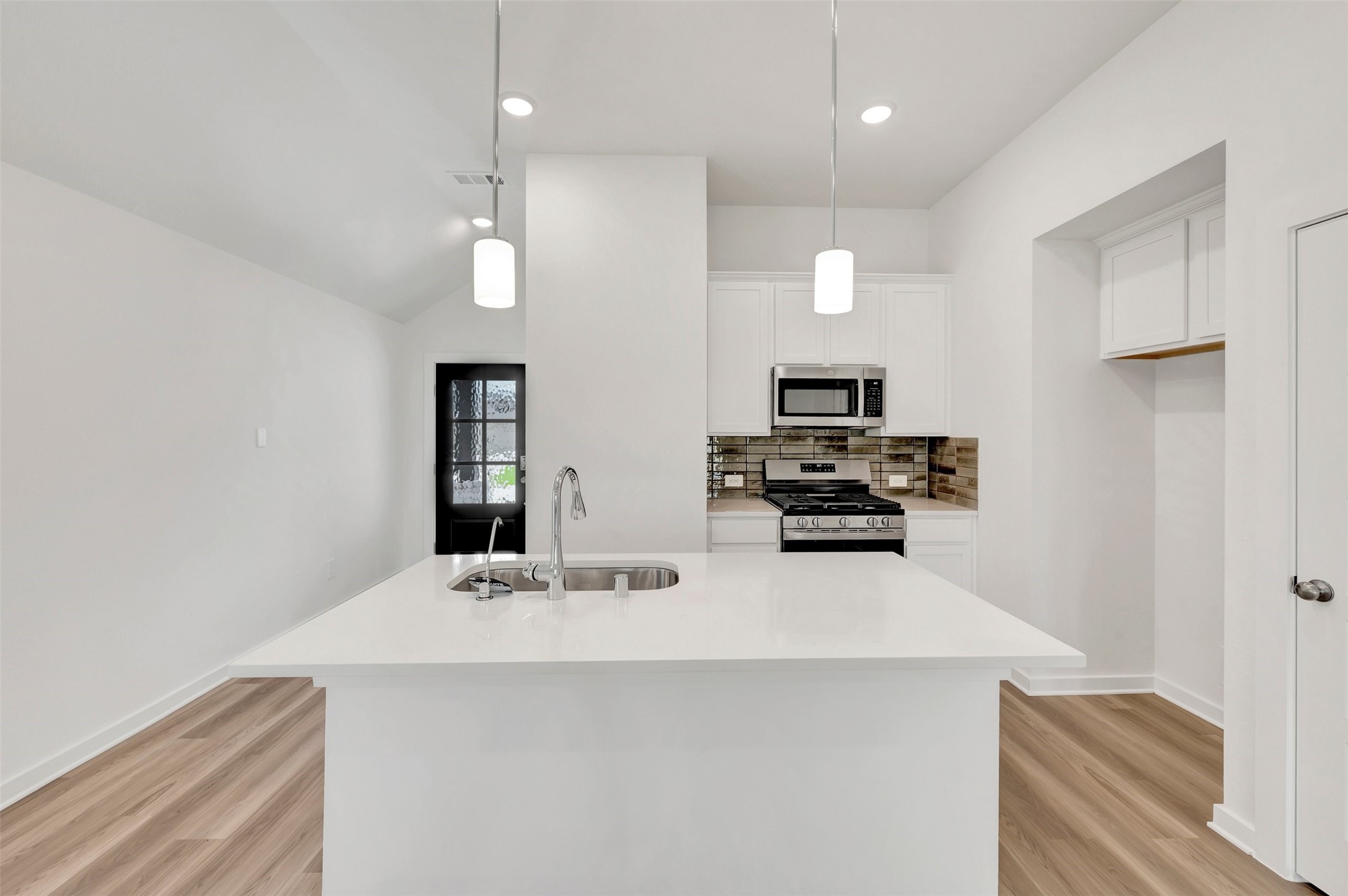 543 Flower Reed Court Magnolia, TX 77354 - Photo 2 of 46 a kitchen with a sink a microwave and cabinets
