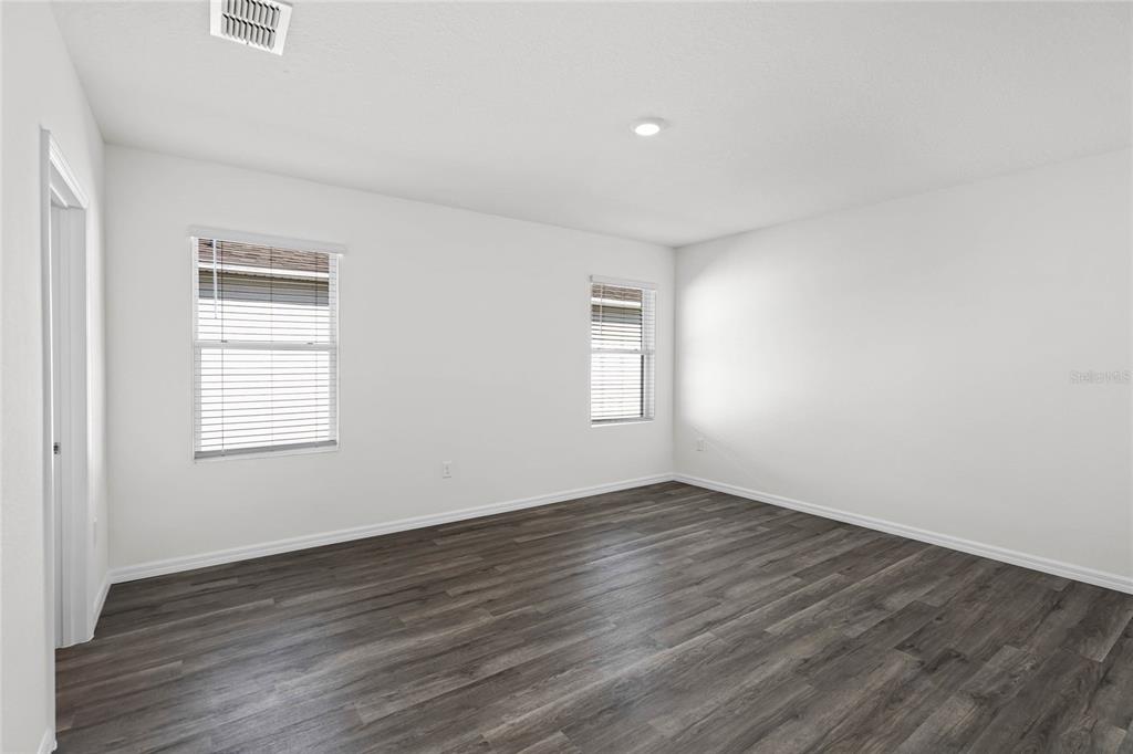 1726 Hummingbird Road Winter Haven, FL 33884 - Photo 12 of 28 an empty room with wooden floor and windows