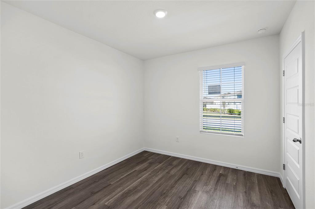 1726 Hummingbird Road Winter Haven, FL 33884 - Photo 18 of 28 an empty room with wooden floor and windows
