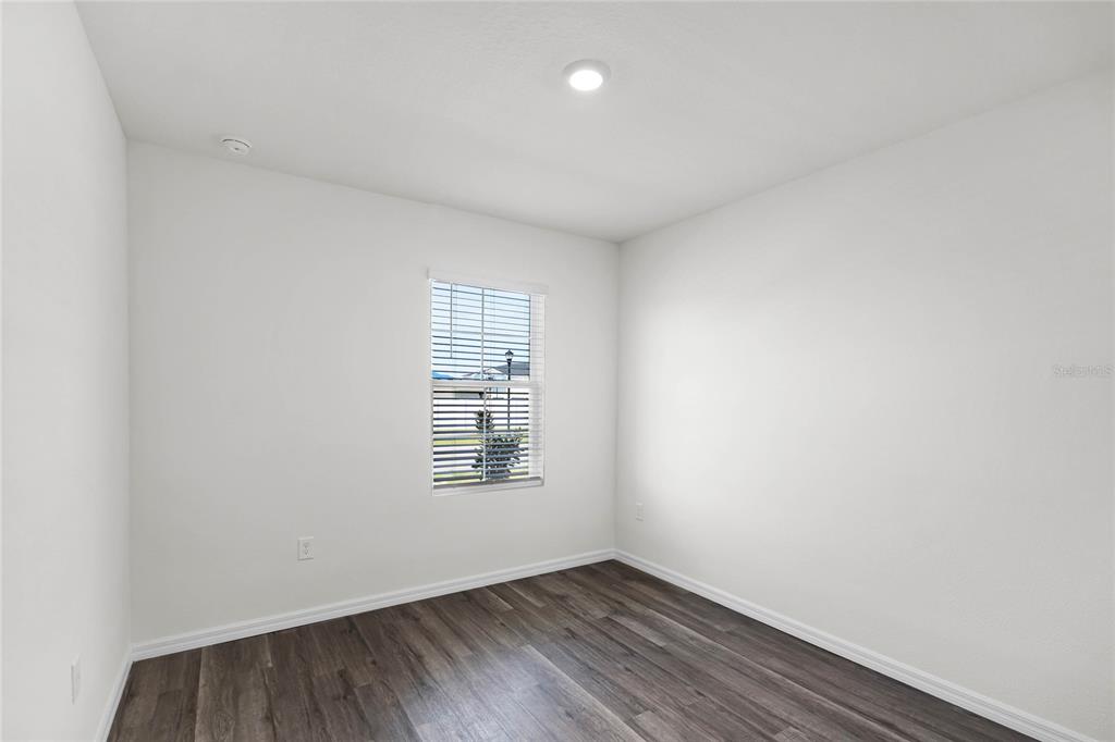 1726 Hummingbird Road Winter Haven, FL 33884 - Photo 22 of 28 an empty room with wooden floor and windows