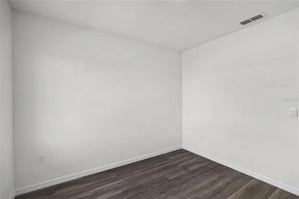 a view of an empty room with wooden floor