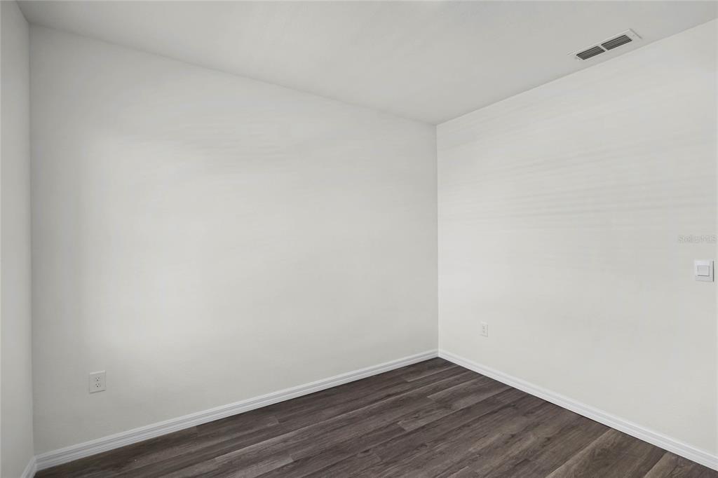 1726 Hummingbird Road Winter Haven, FL 33884 - Photo 25 of 28 a view of an empty room with wooden floor
