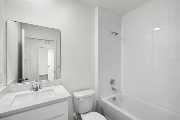 a bathroom with a bathtub shower sink mirror and toilet