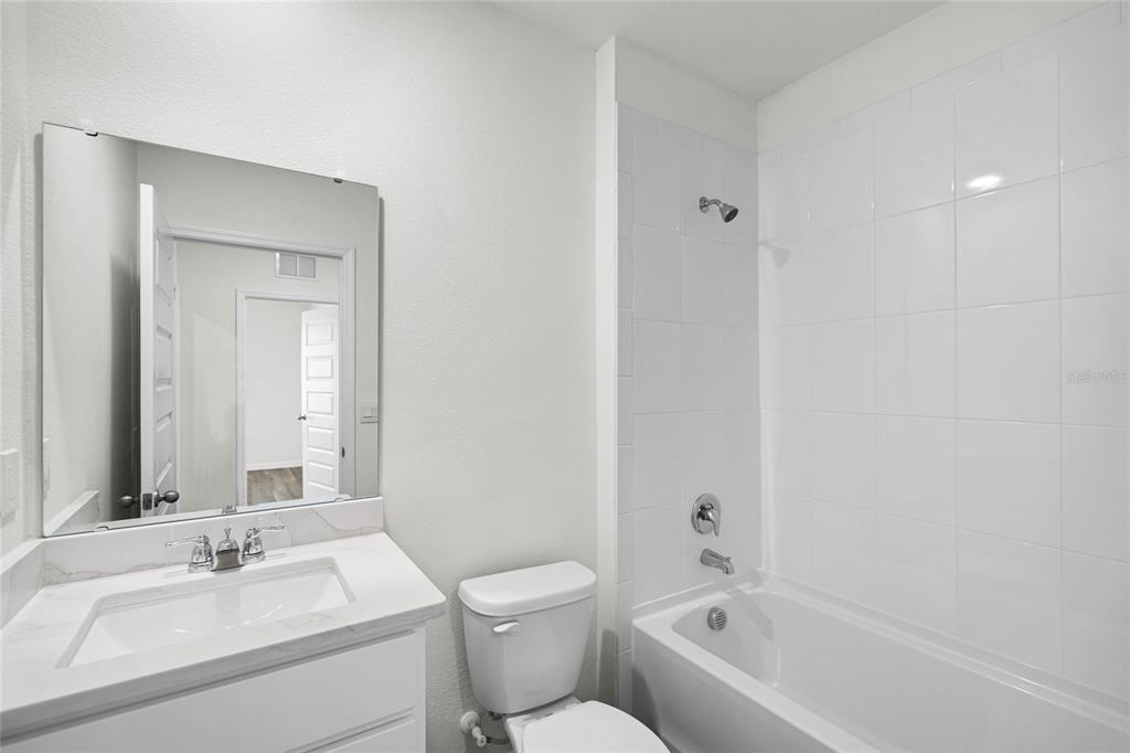 1726 Hummingbird Road Winter Haven, FL 33884 - Photo 26 of 28 a bathroom with a bathtub shower sink mirror and toilet