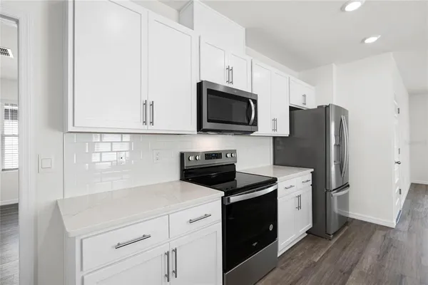 a kitchen with a sink a stove a microwave and refrigerator