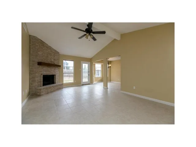 a living room with a fireplace furniture and a ceiling fan