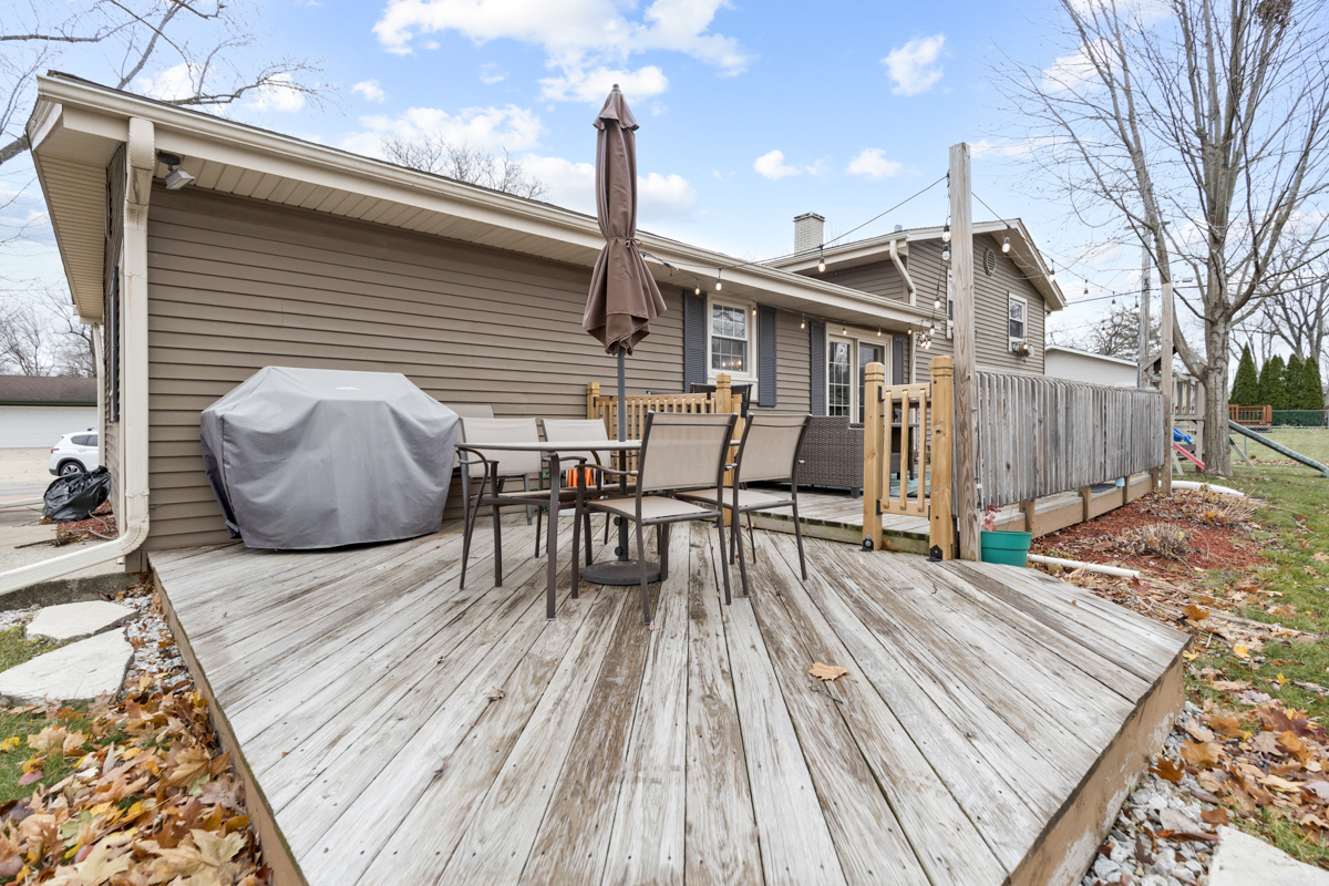 206 Yuma Lane Carol Stream, IL 60188 - Photo 20 of 26 a view of a roof deck with table and chairs with wooden floor and fence