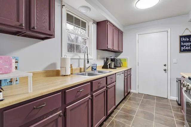 a kitchen with a sink window and cabinets