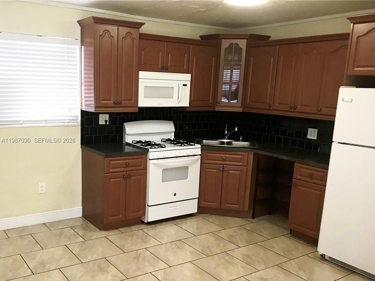 4250 Southwest 67th Avenue, Unit 32 Miami, FL 33155 - Photo 3 of 10 a kitchen with a stove microwave and sink