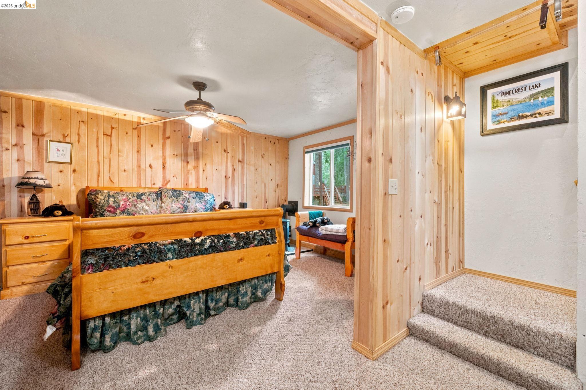 25822 Long Barn Sugar Pine Road Long Barn, CA 95335 - Photo 24 of 28 a spacious bedroom with a bed and a chandelier