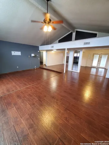 a view of empty room with wooden floor
