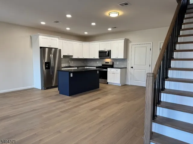 a kitchen with stainless steel appliances granite countertop a refrigerator and a stove top oven