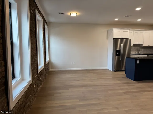 a view of a refrigerator in kitchen and wooden floor