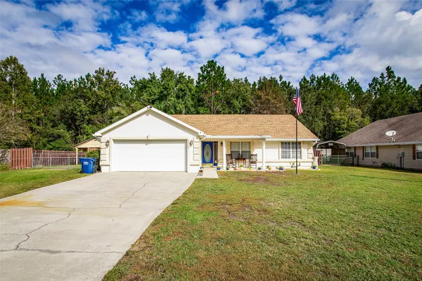 a front view of a house with a yard and trees