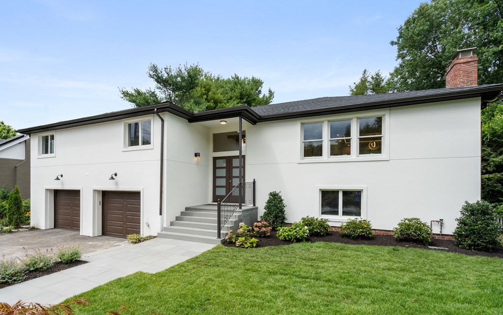a front view of a house with a garden and plants