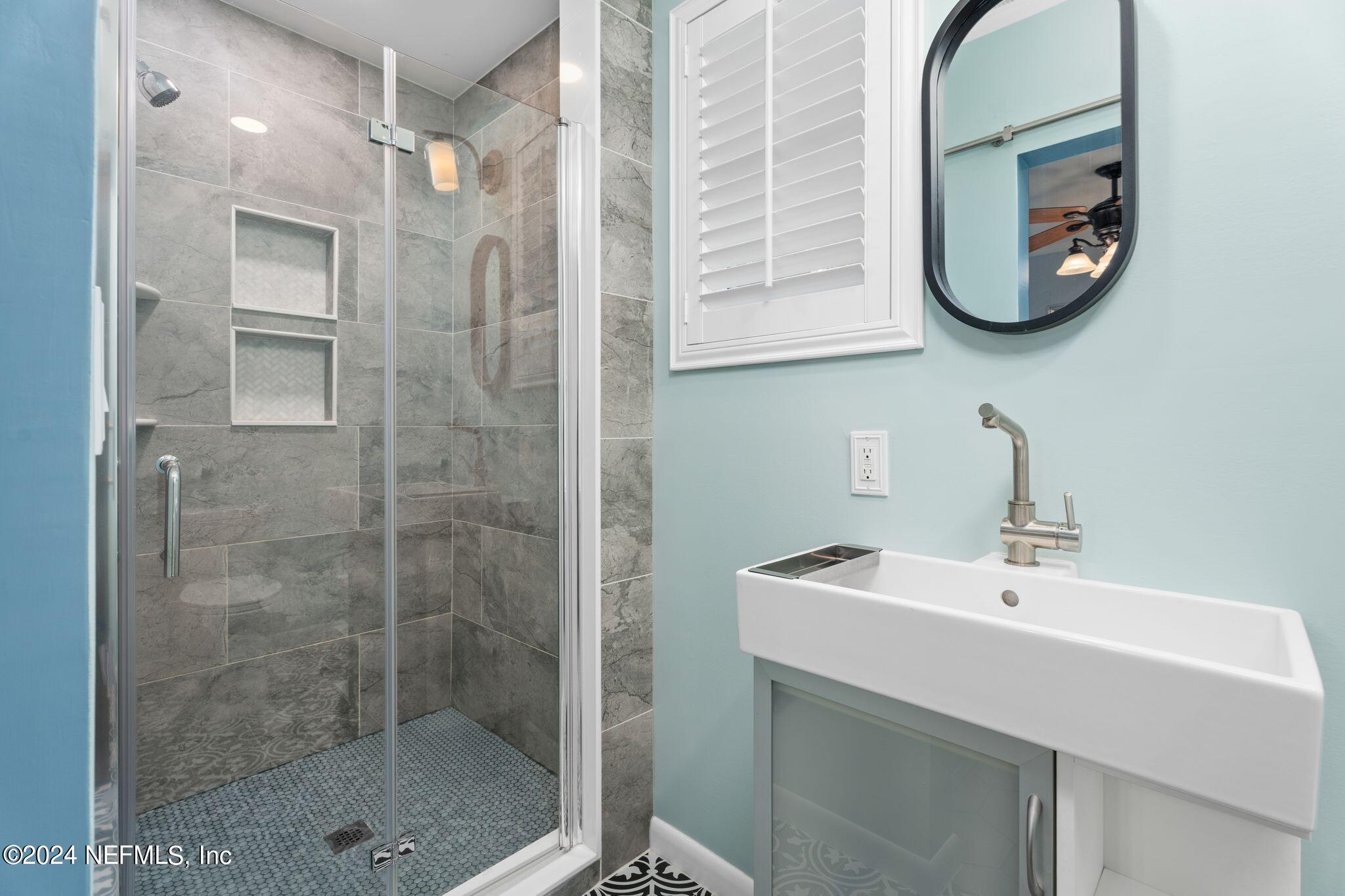 1704 Furman Road Jacksonville, FL 32217 - Photo 14 of 26 a bathroom with a sink a glass door shower and a mirror