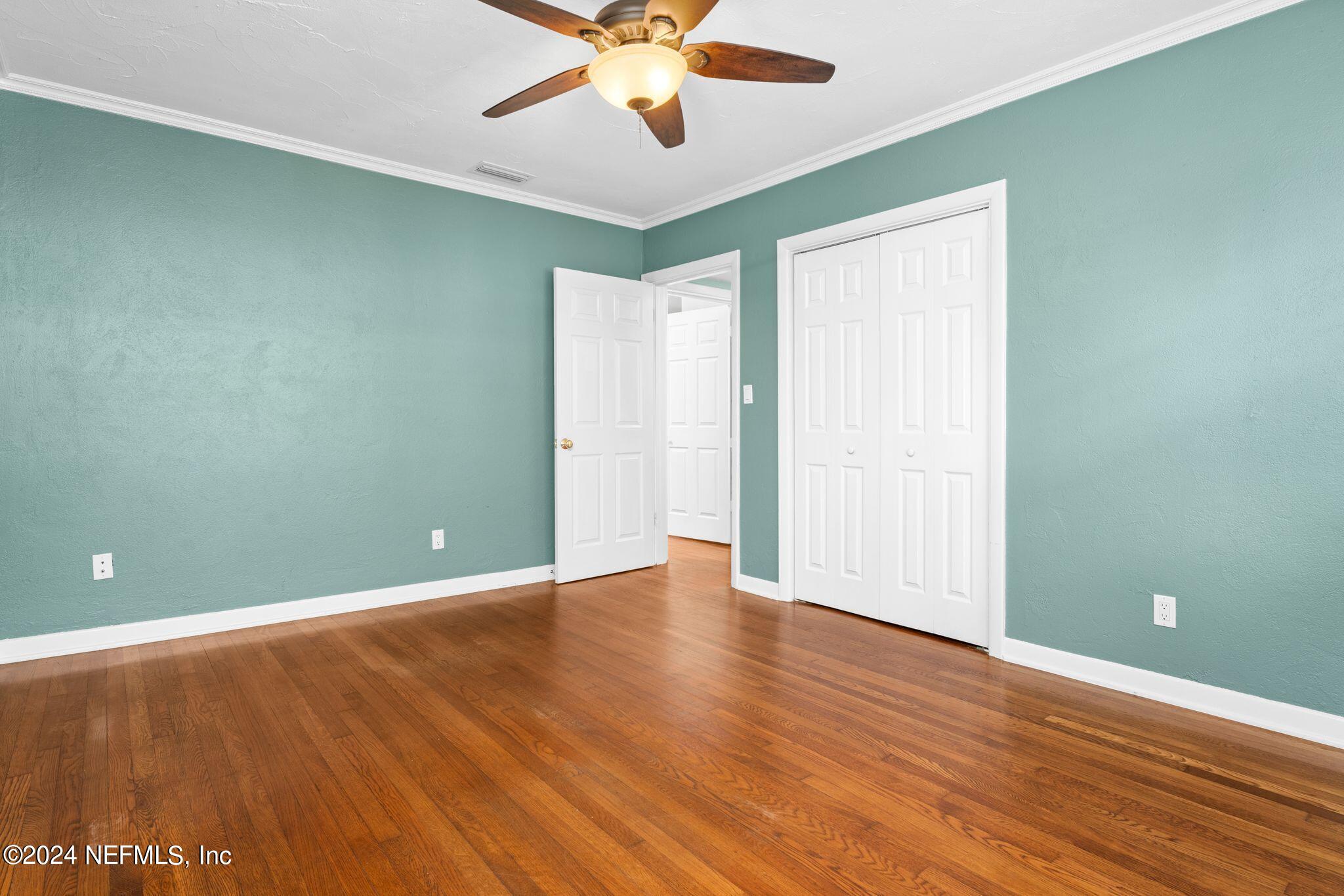 1704 Furman Road Jacksonville, FL 32217 - Photo 18 of 26 an empty room with wooden floor fan and windows