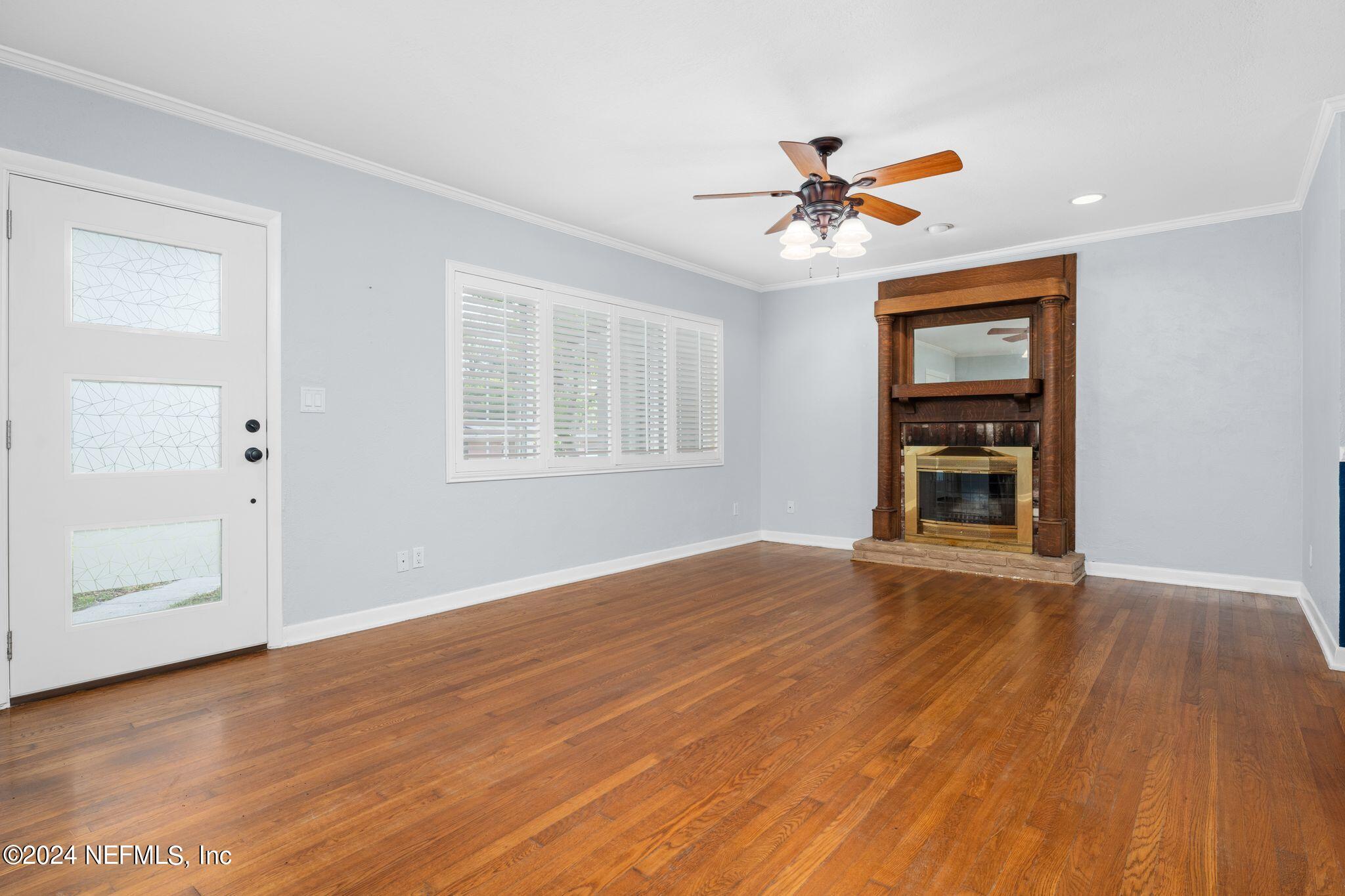 1704 Furman Road Jacksonville, FL 32217 - Photo 3 of 26 an empty room with wooden floor chandelier fan and windows