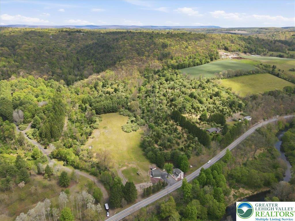 4880 Little Gap Road Kunkletown, PA 18058 - Photo 97 of 100 An aerial perspective reveals a serene landscape of rolling hills, lush woodlands, and a tranquil river.
