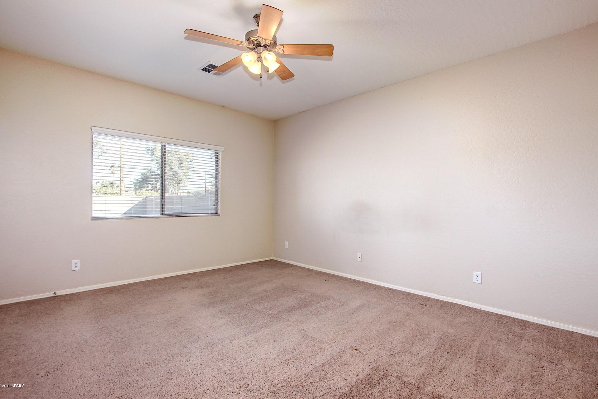 3036 East St John Road Phoenix, AZ 85032 - Photo 15 of 33 an empty room with windows and chandelier fan