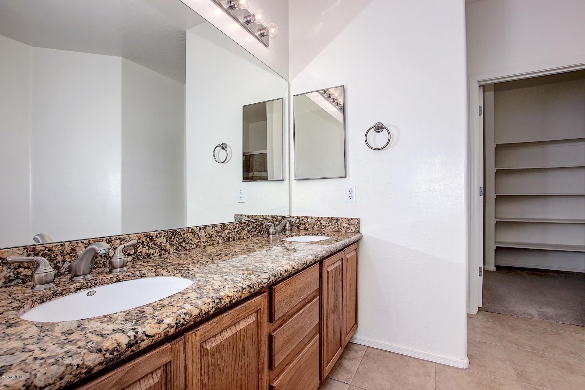 3036 East St John Road Phoenix, AZ 85032 - Photo 19 of 33 a bathroom with a granite countertop sink and a mirror