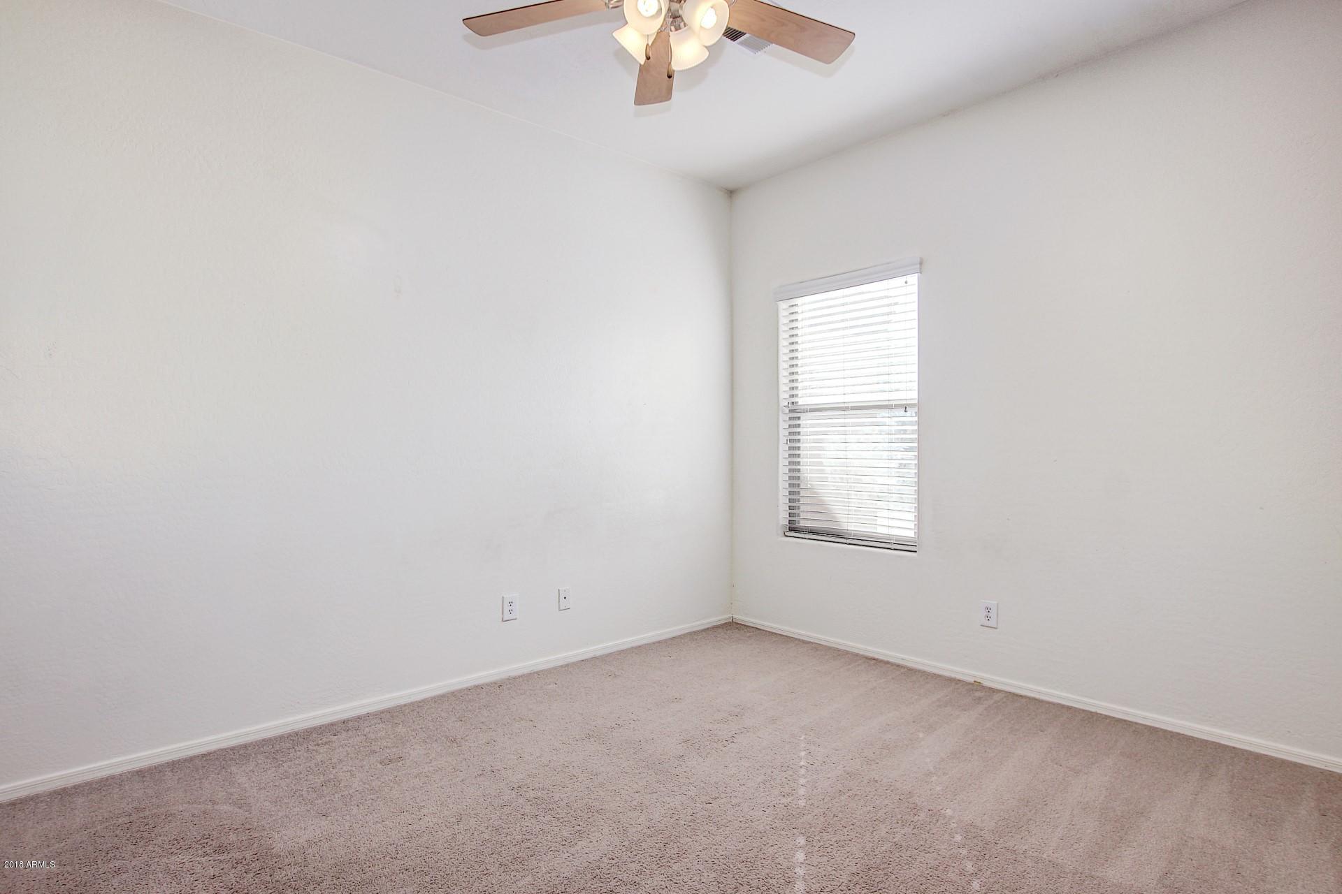 3036 East St John Road Phoenix, AZ 85032 - Photo 23 of 33 an empty room with a window and a chandelier fan
