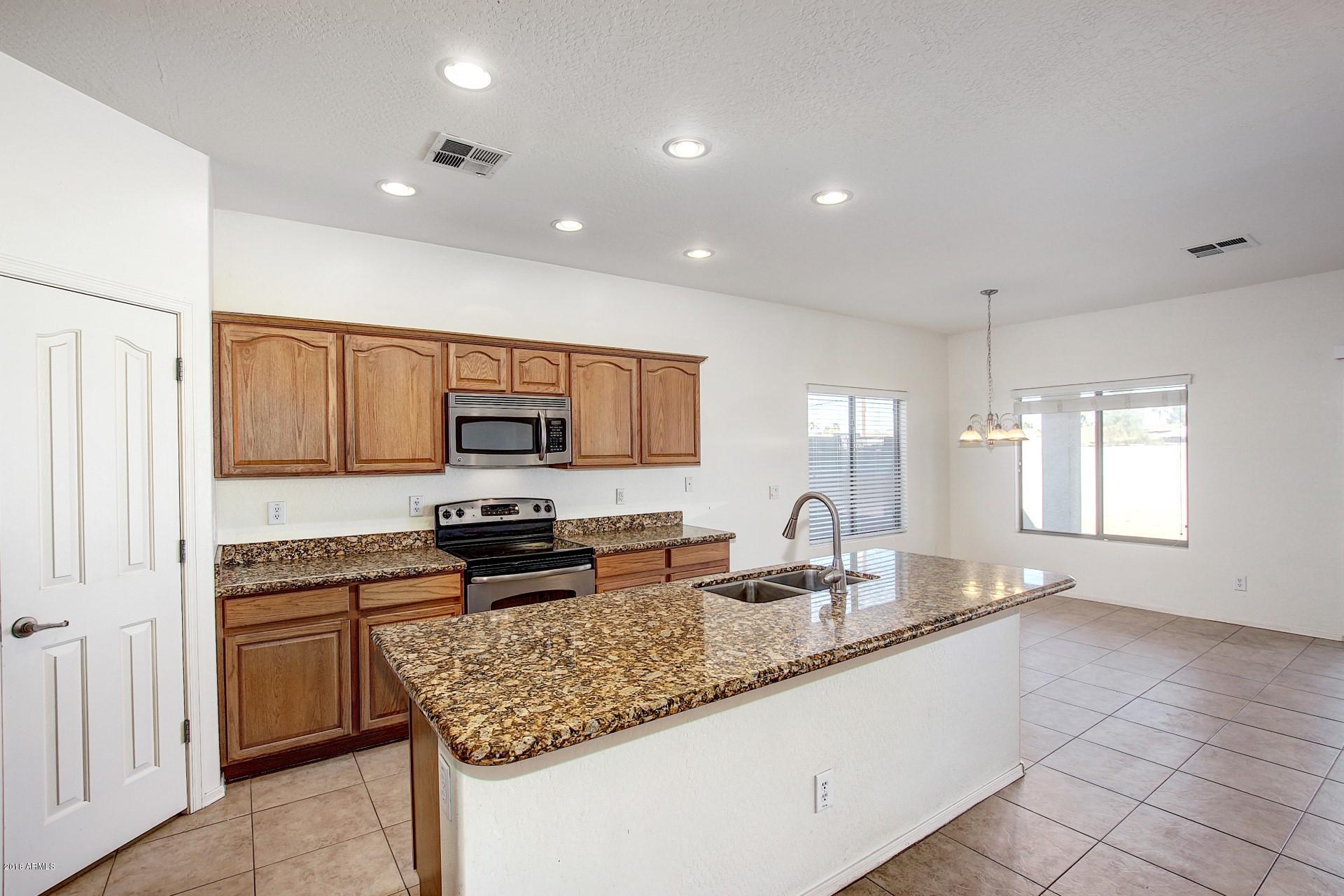 3036 East St John Road Phoenix, AZ 85032 - Photo 5 of 33 a kitchen with stainless steel appliances granite countertop a sink stove and refrigerator